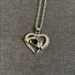 Mother’s hand holding baby’s hand necklace